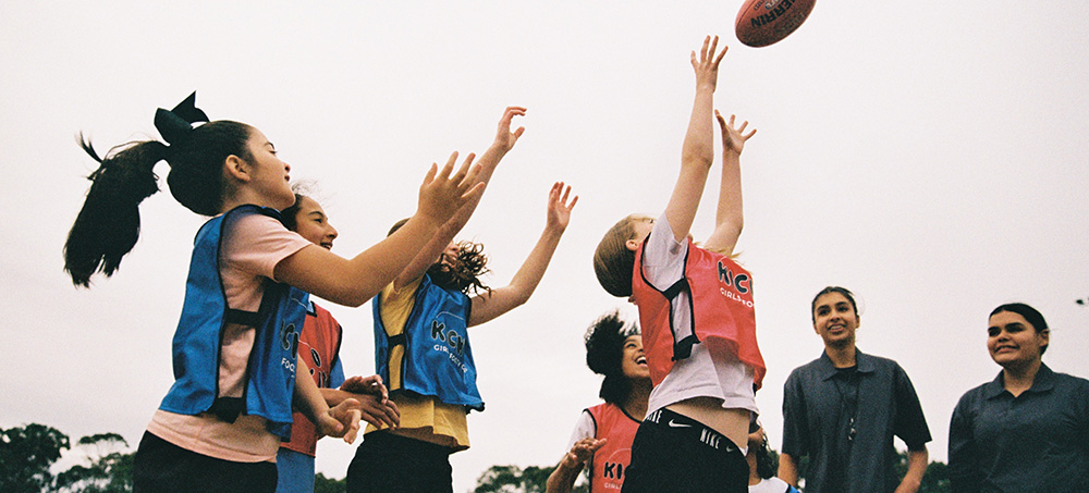 A group of young girls playing footy