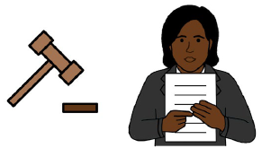 A gavel next to a person pointing out part of a document.